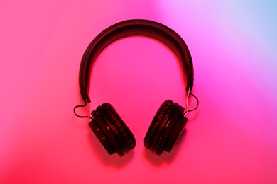 Stylish headphones on color background, top view