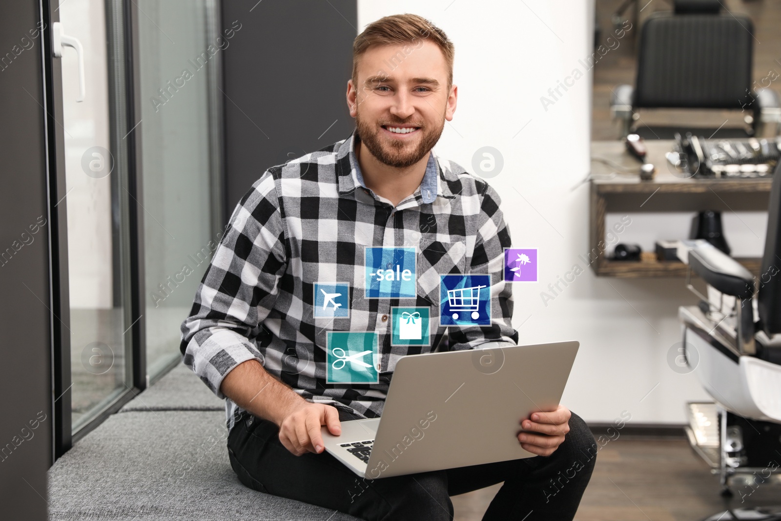 Image of Young man using laptop in barber shop. Online shopping