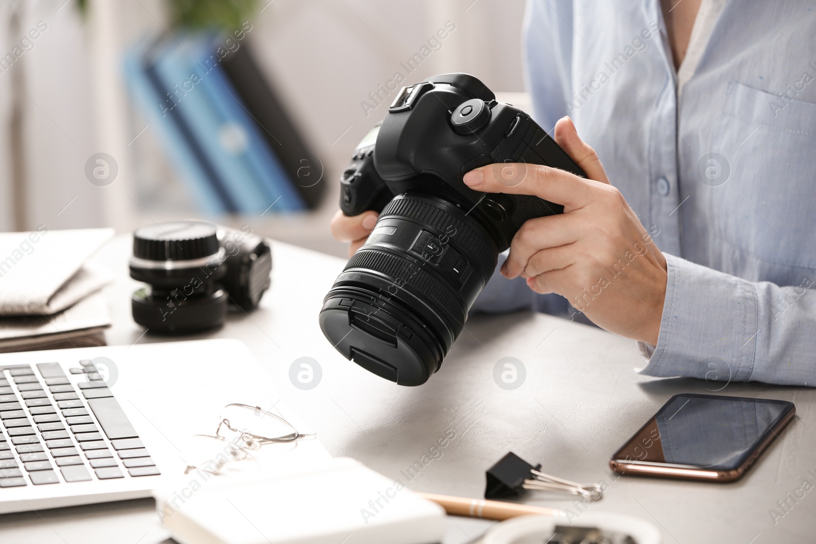 Photo of Journalist with camera working at table, closeup