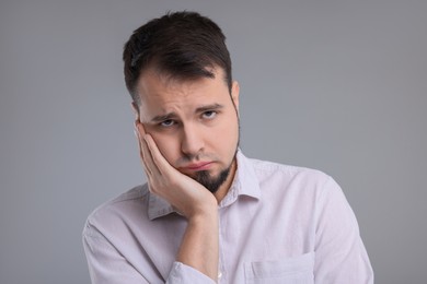 Photo of Portrait of sad man on grey background