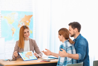 Female manager consulting couple in travel agency