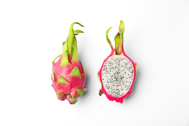 Delicious cut and whole dragon fruits (pitahaya) on white background, top view