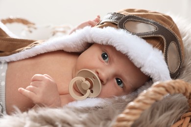 Adorable newborn baby with pacifier on light background