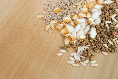 Different vegetable seeds on wooden table, closeup. Space for text