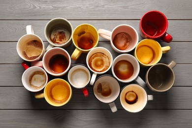 Many dirty cups after drinking coffee on grey wooden table, flat lay