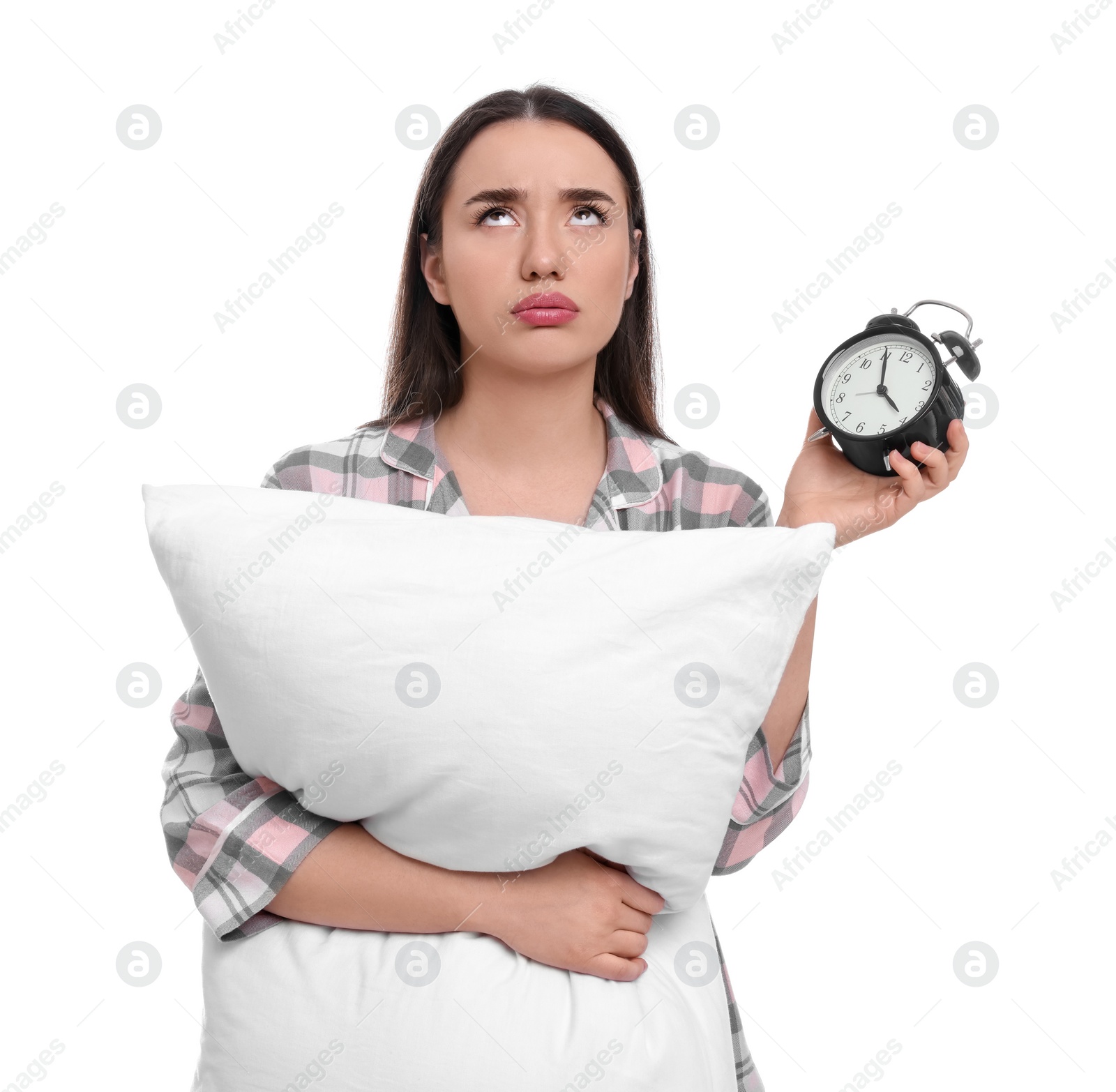 Photo of Tired young woman with alarm clock and pillow on white background. Insomnia problem