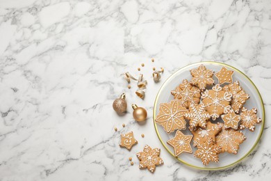 Tasty Christmas cookies and baubles on white marble table, flat lay. Space for text