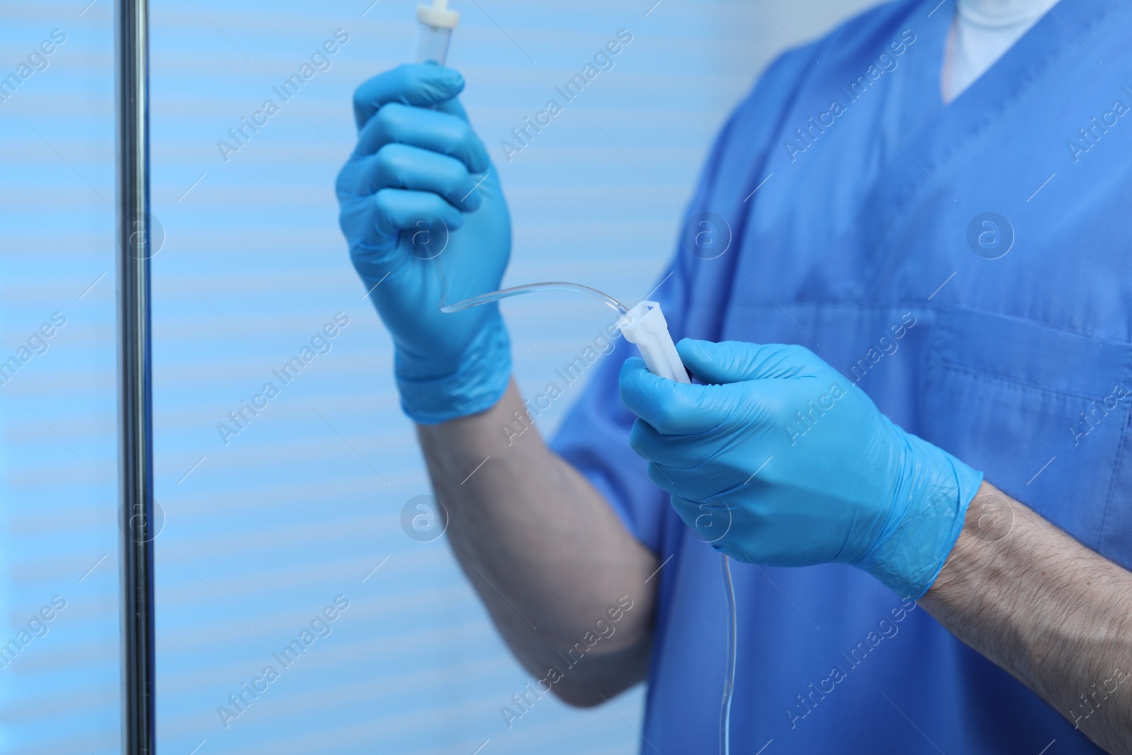 Photo of Nurse setting up IV drip in hospital, closeup