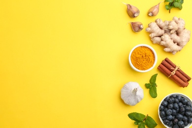 Flat lay composition with different natural antibiotics on yellow background, space for text