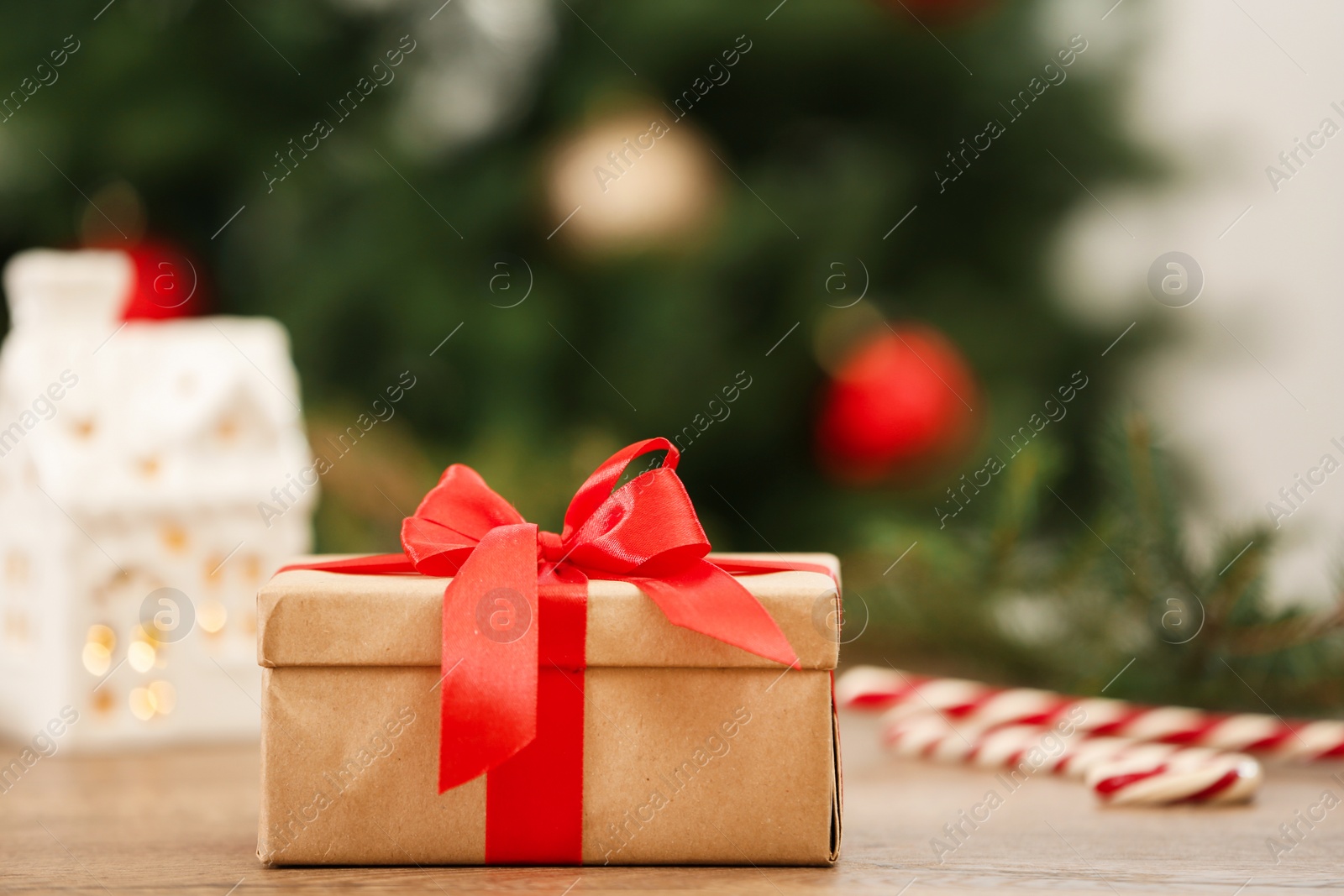 Photo of Christmas gift on table against blurred background