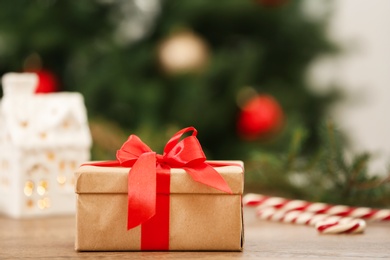 Photo of Christmas gift on table against blurred background