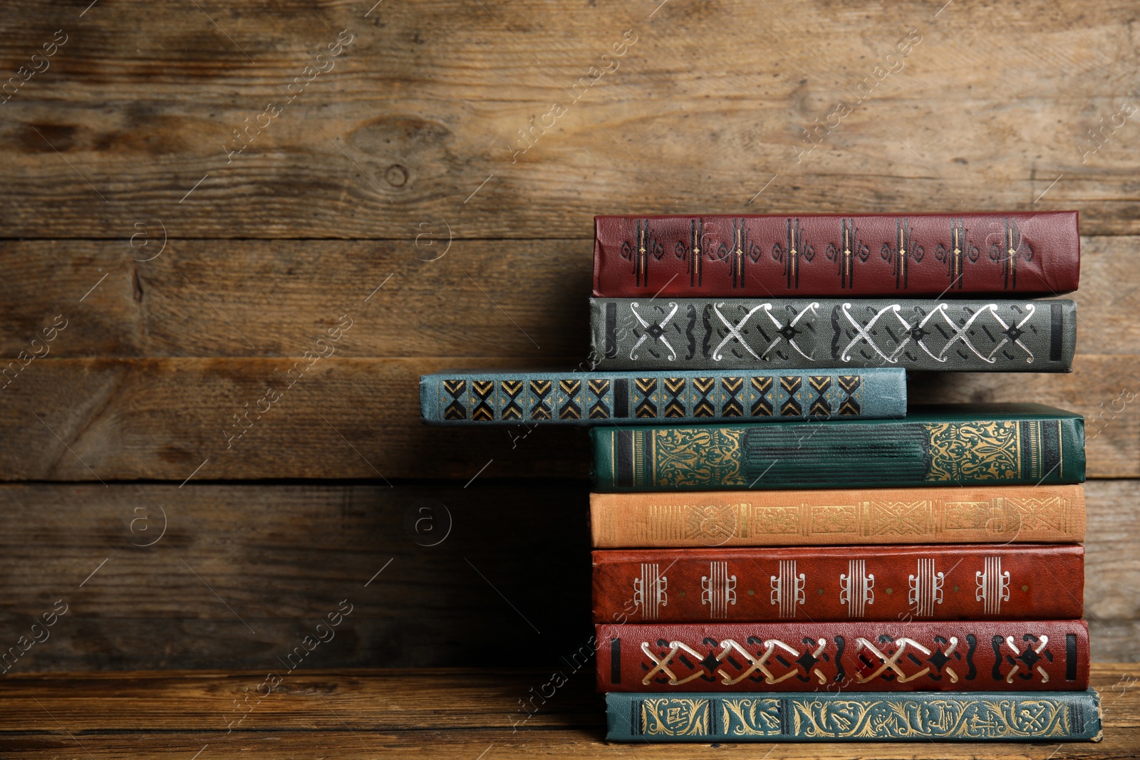 Photo of Collection of different books on table against wooden background. Space for text