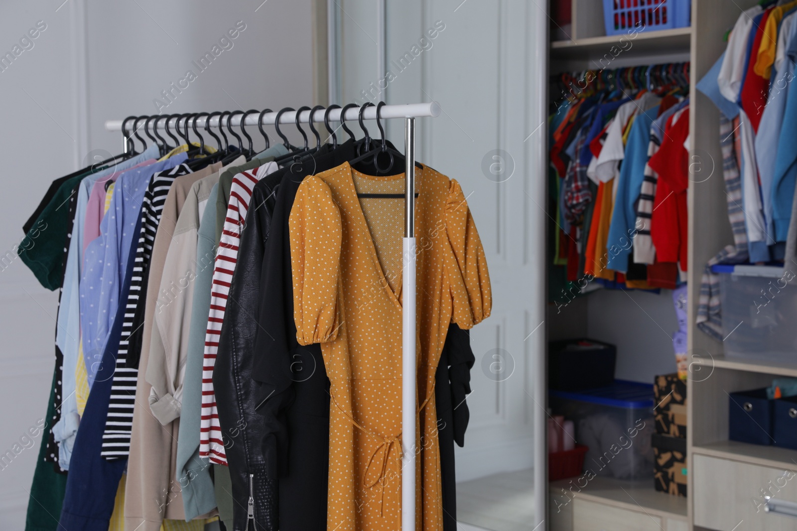 Photo of Rack with stylish women's clothes in dressing room