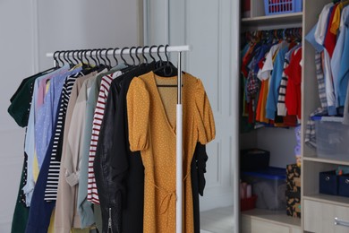 Photo of Rack with stylish women's clothes in dressing room