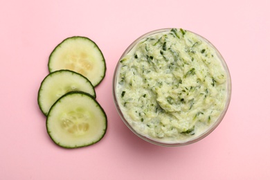 Photo of Handmade face mask and cucumber slices on pink background, flat lay