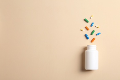 Flat lay composition with bottle, pills and space for text on color background