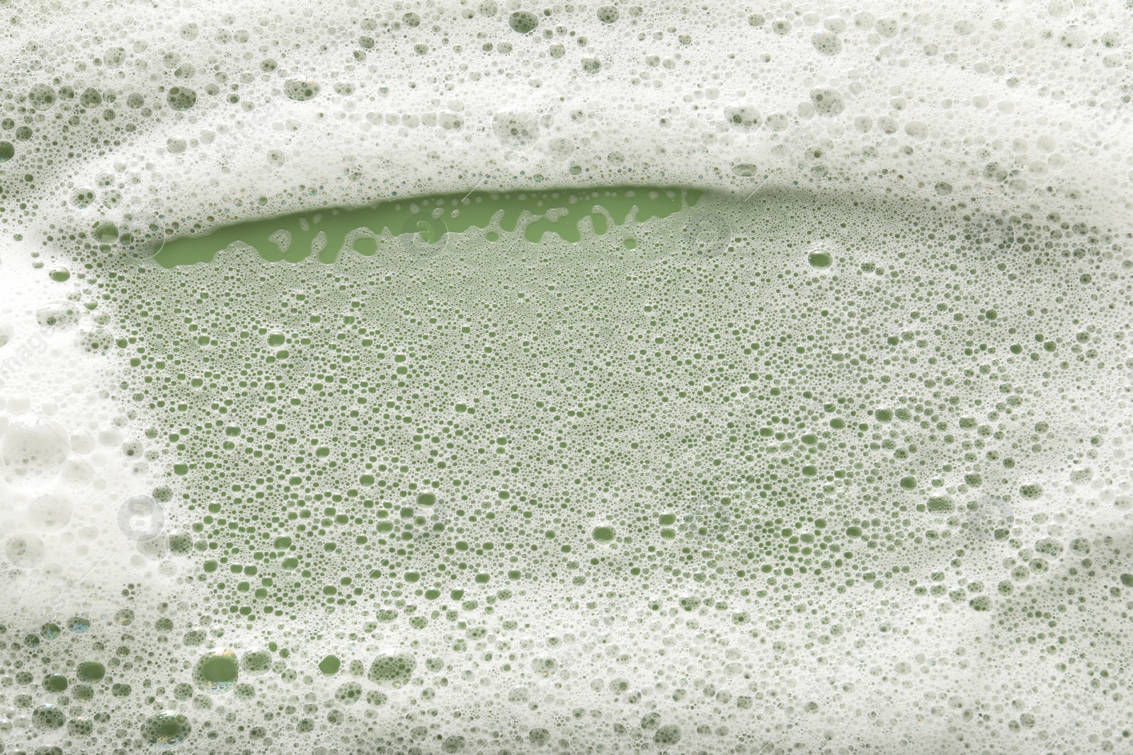 Photo of White washing foam on olive background, top view
