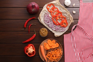 Flat lay composition with striped apron and different ingredients on wooden table
