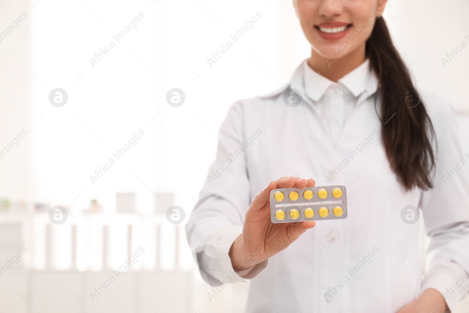 Photo of Professional pharmacist with pills in drugstore, closeup. Space for text