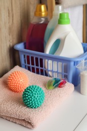Photo of Dryer balls, detergents and clean towel on washing machine