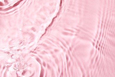Closeup view of water with rippled surface on pink background