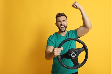 Photo of Emotional man with steering wheel on yellow background. Space for text