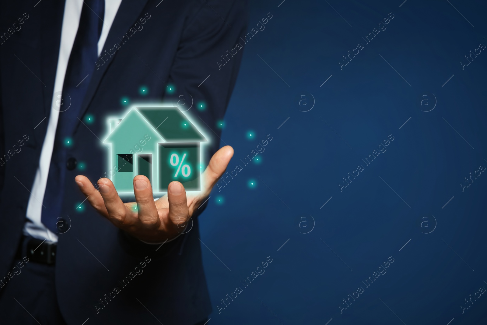 Image of Mortgage rate. Man holding virtual house with percent sign on dark blue background, closeup. Space for text