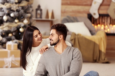 Image of Happy couple in living room decorated for Christmas