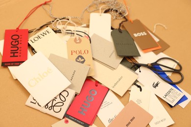 Photo of Leiden, Netherlands - December 6, 2023: Different clothing tags and scissors on kraft paper sheet