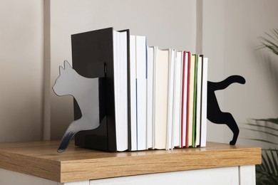 Photo of Minimalist cat bookends with books on table indoors