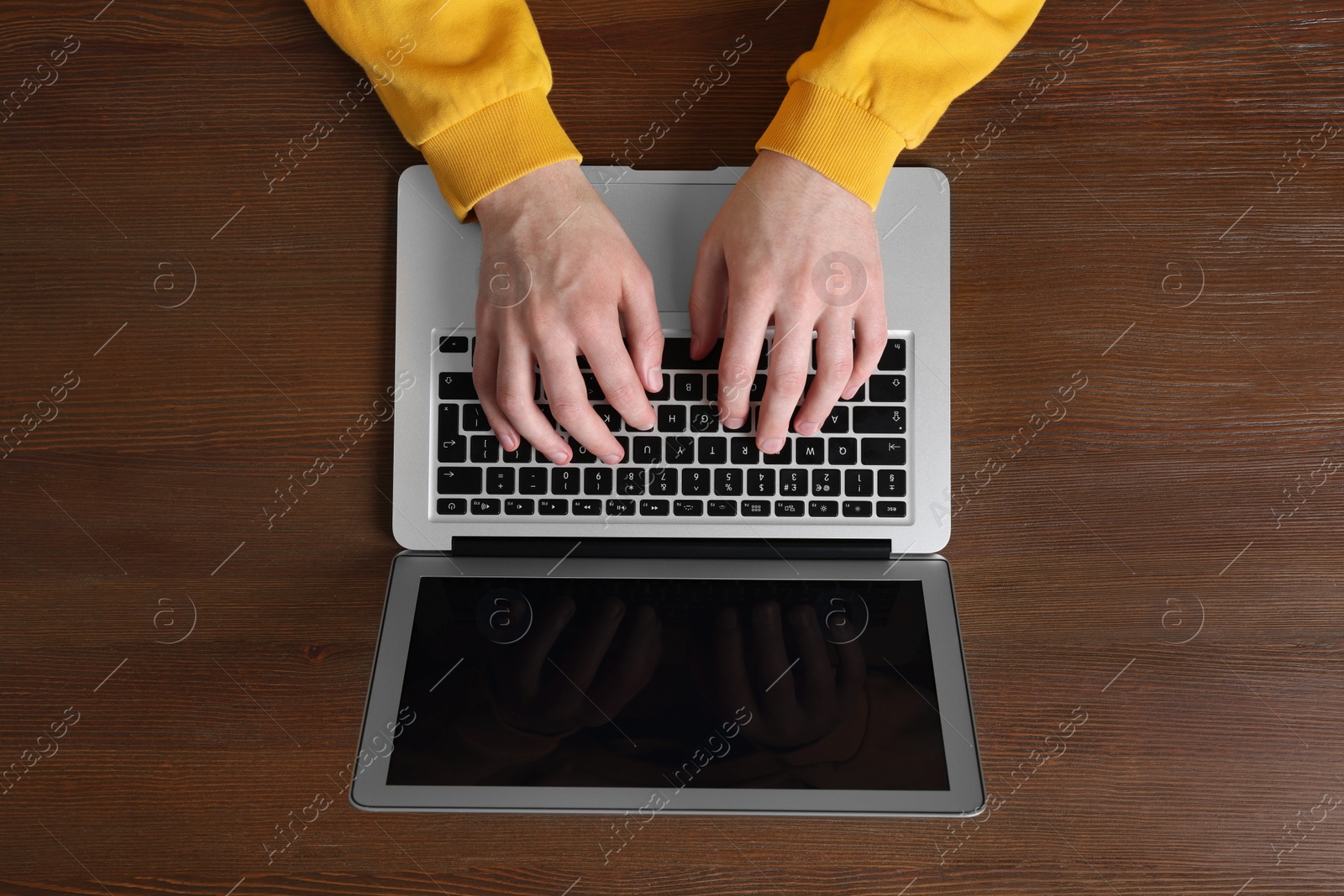 Photo of Man working with laptop at wooden table, top view