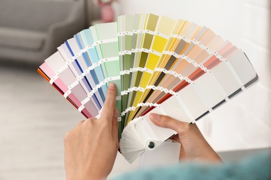 Female interior designer with color palette samples indoors, closeup