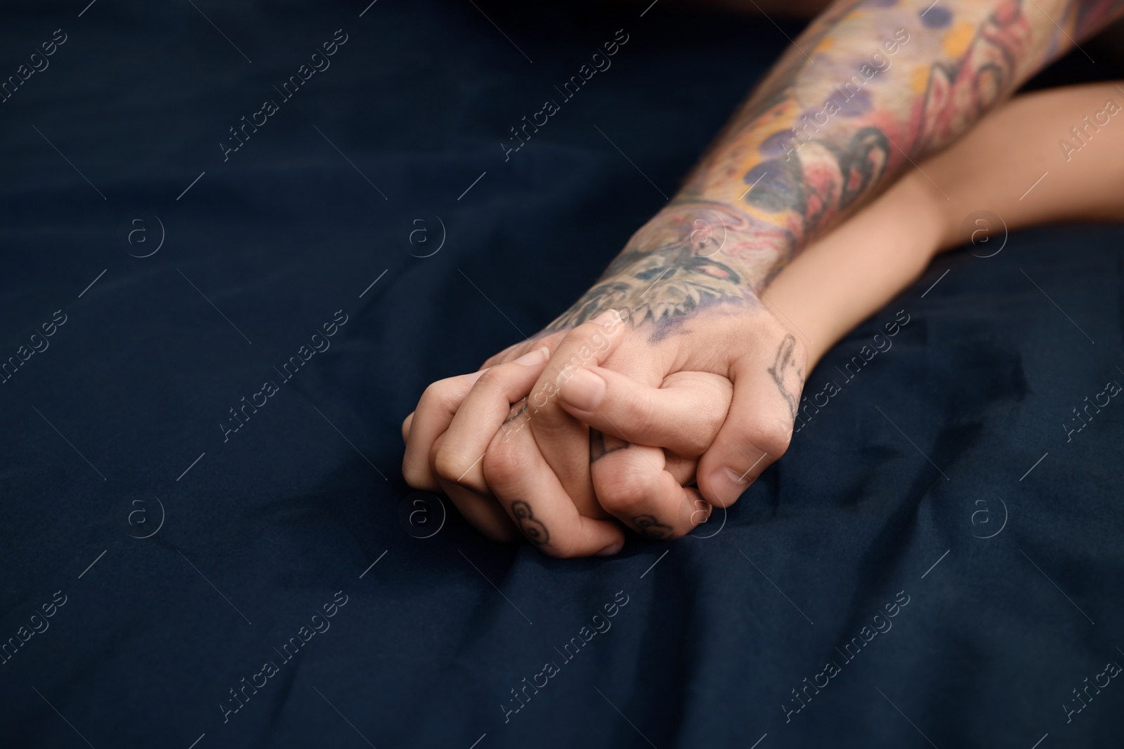 Photo of Passionate couple having sex on bed, closeup of hands