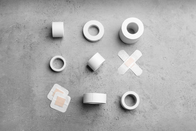 Different types of sticking plasters on stone background, flat lay