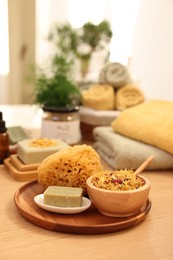 Photo of Dry flowers, loofah and soap bar on wooden table indoors, space for text. Spa time