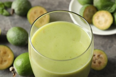 Photo of Fresh feijoa smoothie in glass on table, closeup view