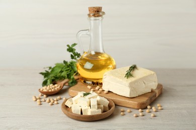 Pieces of delicious tofu with herbs, oil and soy on white table