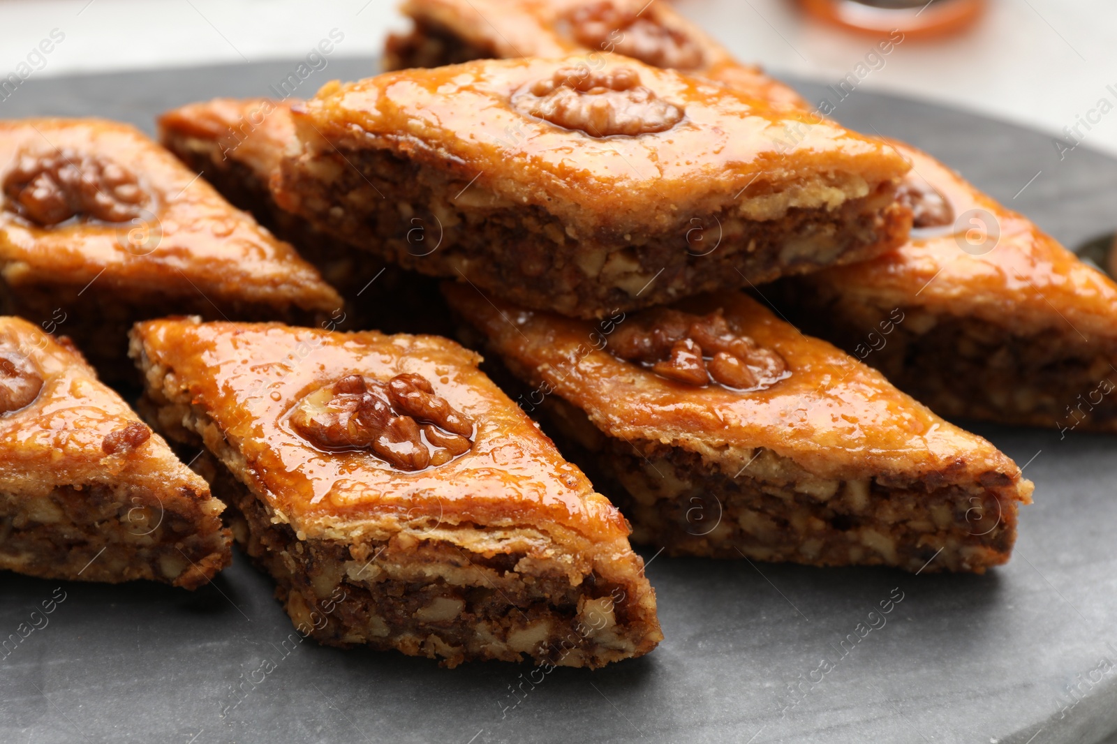 Photo of Delicious sweet baklava with walnuts on board, closeup