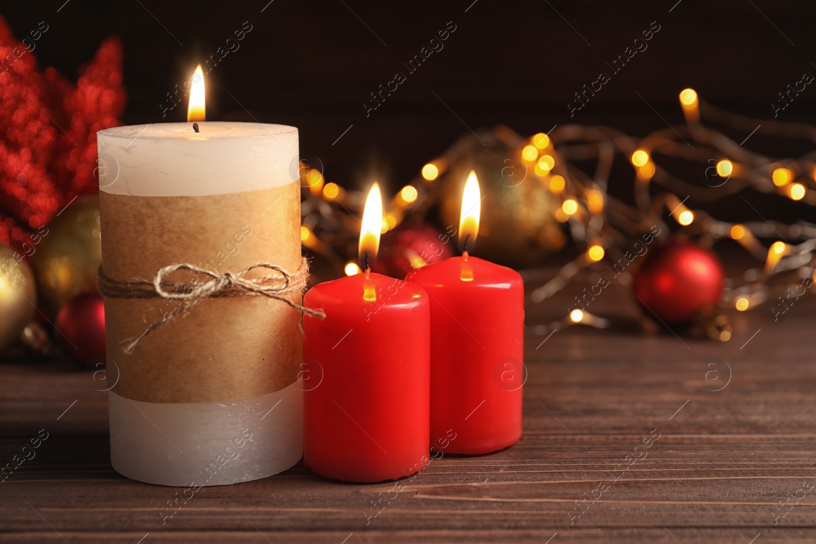 Photo of Beautiful composition with burning wax candles on table against blurred lights