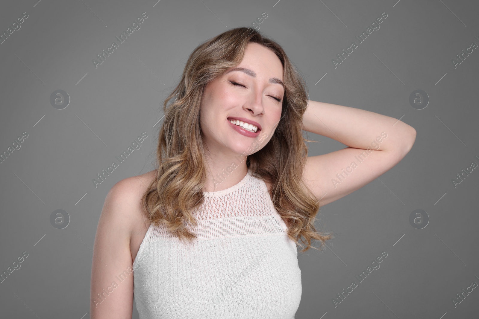 Photo of Portrait of smiling woman on grey background