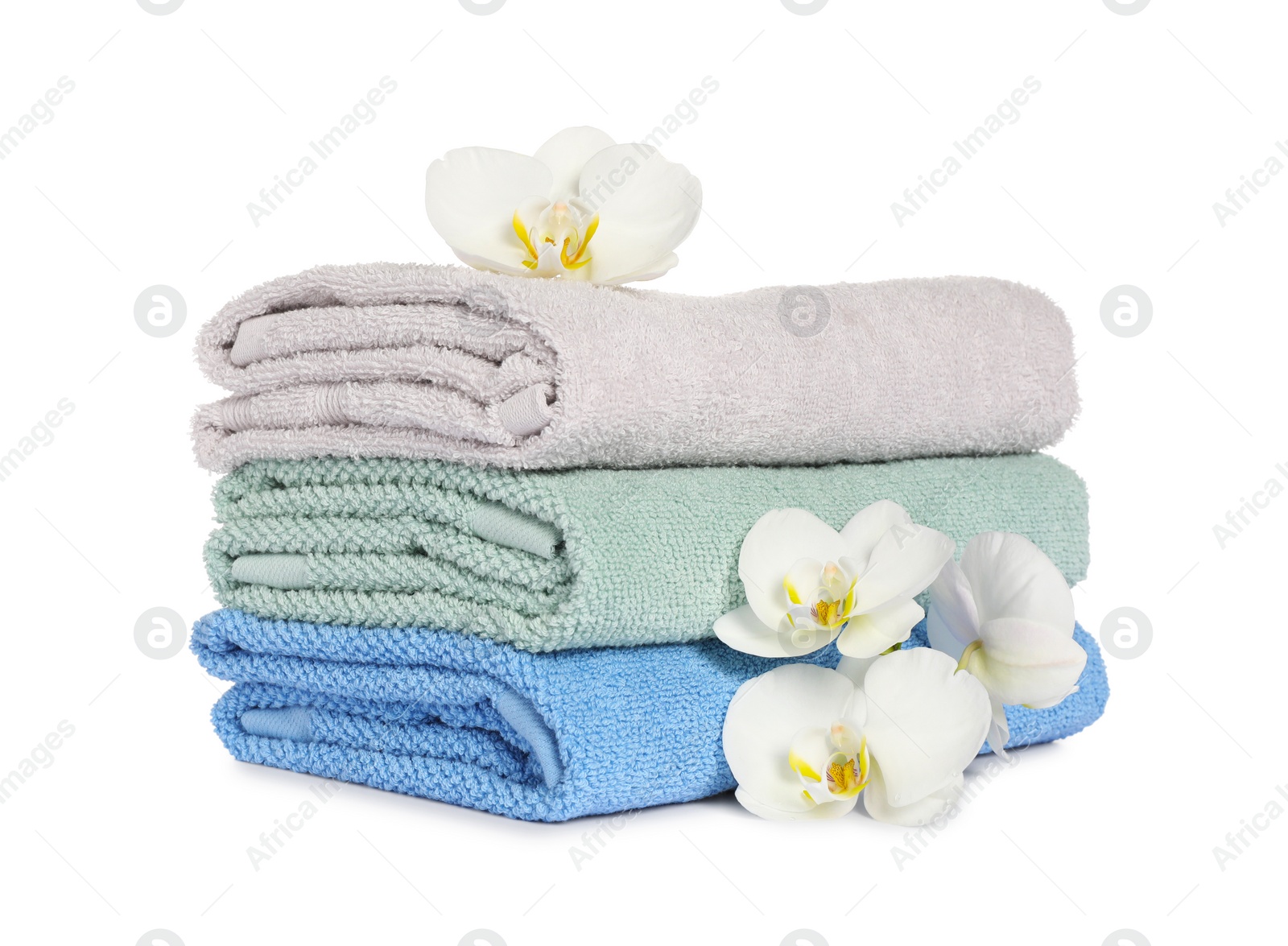 Photo of Stack of clean soft towels with orchids isolated on white