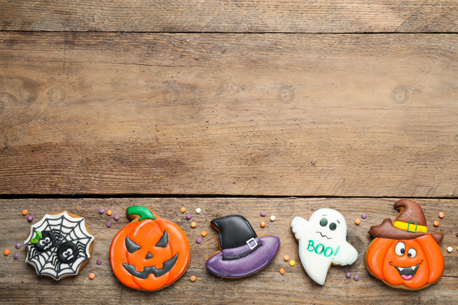 Photo of Tasty Halloween cookies on wooden table, flat lay. Space for text