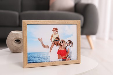 Pleasant memories. Wooden photo frame with family portrait on white table indoors, closeup
