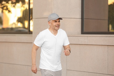 Photo of Handsome mature man running on street. Healthy lifestyle