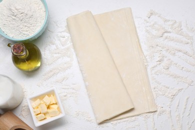 Photo of Fresh dough and different ingredients for making baklava on white table, flat lay