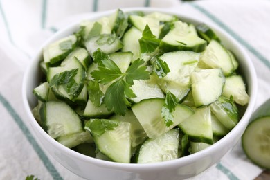 Delicious cucumber salad in bowl on table, closeup