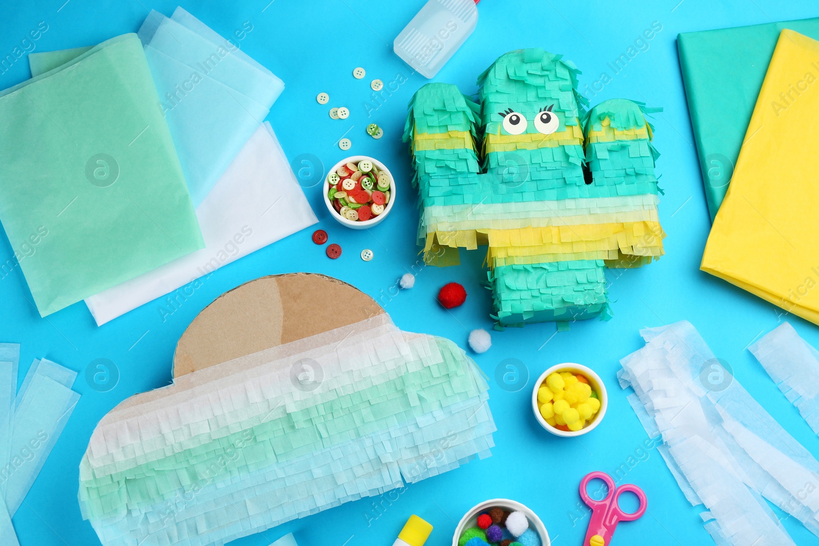 Photo of Flat lay composition with cardboard cactus and cloud on light blue background. Pinata diy