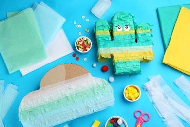 Photo of Flat lay composition with cardboard cactus and cloud on light blue background. Pinata diy