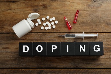 Photo of Black cubes with word Doping and drugs on wooden background, flat lay