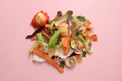 Photo of Peels of fresh vegetables on pink background, flat lay